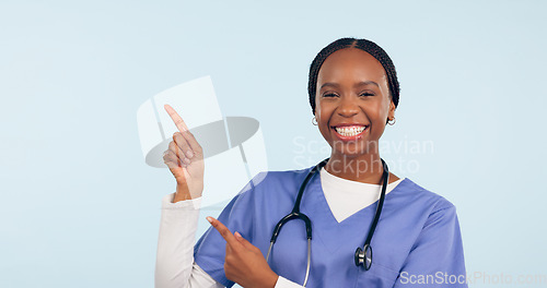 Image of Black woman, nurse and pointing at medical information, list or announcement with smile in portrait on blue background. Healthcare news, advertising and mockup for health alert and about us in studio