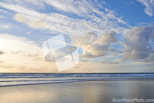 Image of Seascape and landscape of a golden sunset on the west coast of Jutland in Loekken, Denmark. Beautiful cloudscape on an empty beach at dusk. Clouds over the ocean and sea in the morning