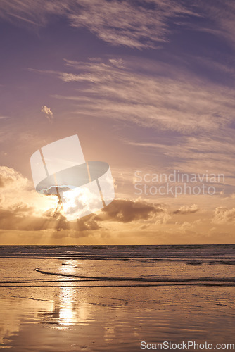 Image of Seascape of a beautiful sunset on the west coast of Jutland in Loekken, Denmark. Sun setting on the horizon on an empty beach at dusk over the ocean and sea at night with copyspace