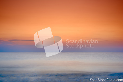 Image of Copyspace seascape of an orange sunset on the west coast of Jutland in Loekken, Denmark. Sun setting on the horizon on an empty beach at dusk over the ocean and sea at night. Sunrise in the morning