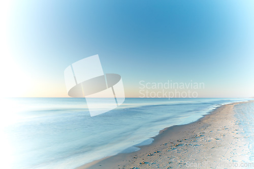 Image of Copyspace seascape and landscape of a pretty sunset on the westcoast of Jutland in Loekken, Denmark. Beautiful view on an empty beach at dusk. Sun rising over the ocean and sea in the morning