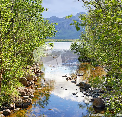 Image of Landscape of lake and river north of polar and arctic circle in Norland. Mountains and hills in remote area with rocky stream in Bodo, Norway. Traveling abroad and overseas for holiday and vacation