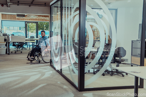 Image of In a large modern corporation, a determined businessman in a wheelchair navigates through a hallway, embodying empowerment and inclusivity in the corporate world.