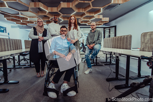 Image of Young businessmen in a modern office extend a handshake to their business colleague in a wheelchair, showcasing inclusivity, support, and unity in the corporate environment.