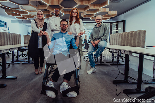 Image of Young businessmen in a modern office extend a handshake to their business colleague in a wheelchair, showcasing inclusivity, support, and unity in the corporate environment.