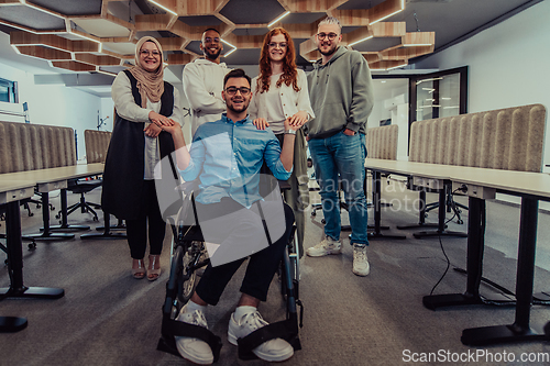 Image of Young businessmen in a modern office extend a handshake to their business colleague in a wheelchair, showcasing inclusivity, support, and unity in the corporate environment.