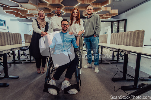 Image of Young businessmen in a modern office extend a handshake to their business colleague in a wheelchair, showcasing inclusivity, support, and unity in the corporate environment.