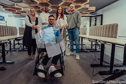 Image of Young businessmen in a modern office extend a handshake to their business colleague in a wheelchair, showcasing inclusivity, support, and unity in the corporate environment.