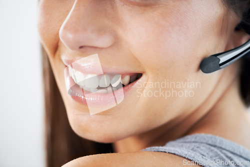 Image of Smile, mouth and headset with a customer service woman closeup in studio for support at a call center. Communication, contact us or crm and a happy young telemarketing employee with a microphone