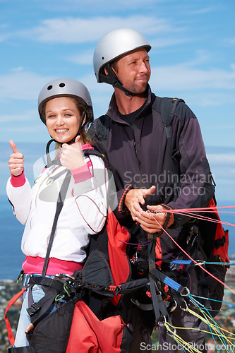 Image of People, thumbs up and outdoor in nature for paragliding, extreme sport and portrait in sunshine. Man, woman and fitness on adventure with helmet, agreement or parachute with yes, review and blue sky