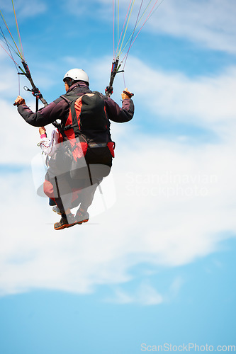 Image of People, paragliding and freedom in sky, nature and extreme sport with back for fitness. Coach, partnership and person with adventure, helmet and fearless with backpack, parachute and jump with safety