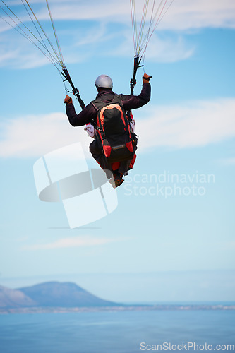 Image of People, paragliding and freedom in sky, ocean and extreme sport with back for fitness. Coach, partnership and person with adventure, helmet and fearless with backpack, parachute and sea with safety