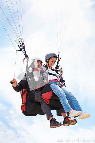 Image of People, paragliding and happy in sky, together or extreme sport with freedom for fitness. Coach, partnership and person on adventure, helmet or fearless with backpack, parachute or flight with clouds