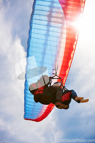 Image of People, paragliding and freedom in sky, below or extreme sport for fitness in sunshine. Coach, partnership and person on adventure, lens flare or fearless with backpack, parachute or flight in clouds