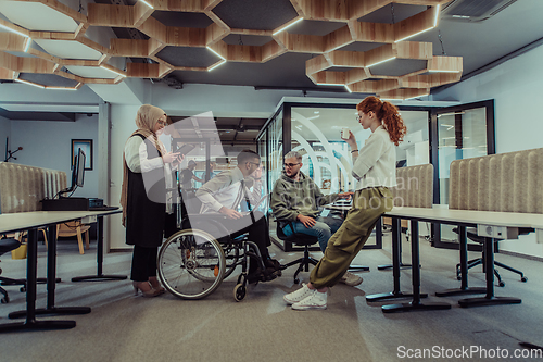 Image of Young group of business people brainstorming together in a startup space, discussing business projects, investments, and solving challenges.