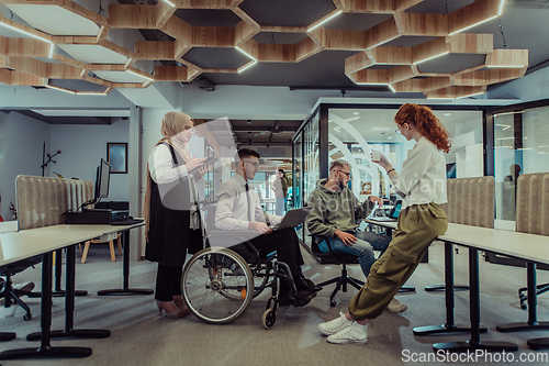 Image of Young group of business people brainstorming together in a startup space, discussing business projects, investments, and solving challenges.