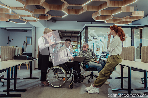 Image of Young group of business people brainstorming together in a startup space, discussing business projects, investments, and solving challenges.