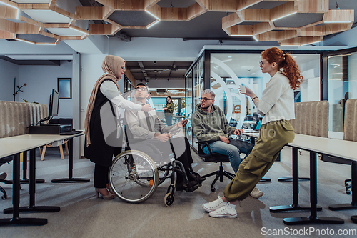 Image of Young group of business people brainstorming together in a startup space, discussing business projects, investments, and solving challenges.