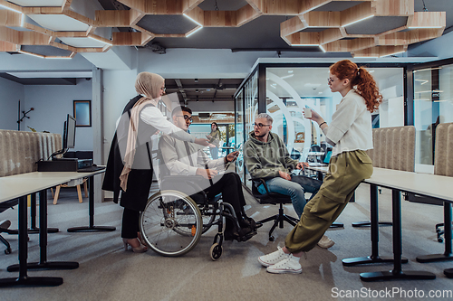 Image of Young group of business people brainstorming together in a startup space, discussing business projects, investments, and solving challenges.