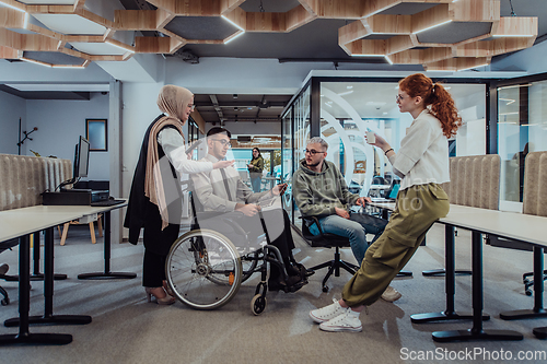 Image of Young group of business people brainstorming together in a startup space, discussing business projects, investments, and solving challenges.