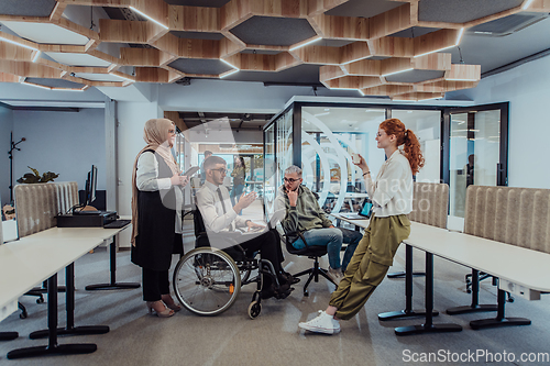 Image of Young group of business people brainstorming together in a startup space, discussing business projects, investments, and solving challenges.