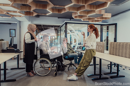 Image of Young group of business people brainstorming together in a startup space, discussing business projects, investments, and solving challenges.