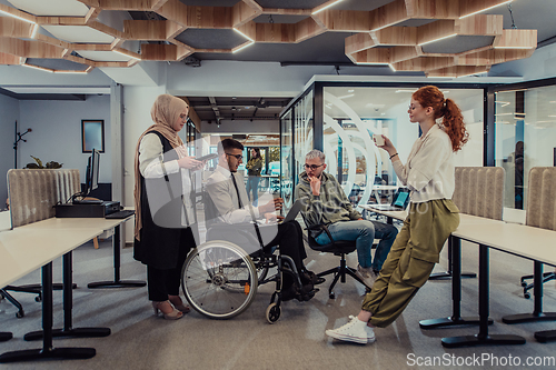 Image of Young group of business people brainstorming together in a startup space, discussing business projects, investments, and solving challenges.