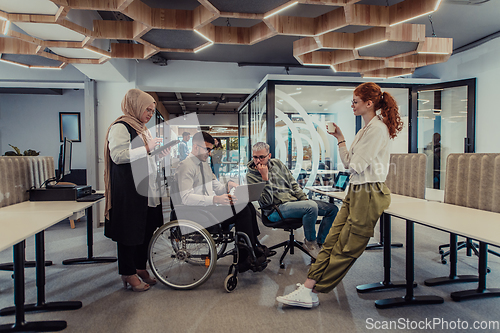 Image of Young group of business people brainstorming together in a startup space, discussing business projects, investments, and solving challenges.