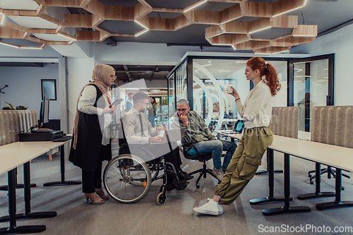 Image of Young group of business people brainstorming together in a startup space, discussing business projects, investments, and solving challenges.