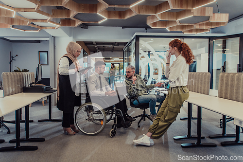 Image of Young group of business people brainstorming together in a startup space, discussing business projects, investments, and solving challenges.