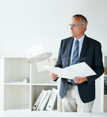 Image of Businessman, standing and documents in office or thinking for contract, report information or confidential file. Male person, suit and company paperwork or corporate agreement, decision or folder