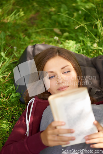 Image of Happy woman in park with book to relax at university, story or studying for school project. Above, reading and college student on grass in campus garden for research, storytelling and peace on lawn.