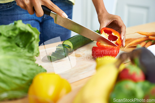 Image of Woman, hands and cutting vegetables in kitchen on wooden board for healthy diet or vegetarian meal at home. Closeup of female person slicing natural organic red pepper for salad preparation at house