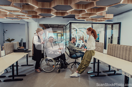 Image of Young group of business people brainstorming together in a startup space, discussing business projects, investments, and solving challenges.