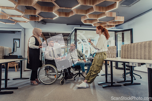 Image of Young group of business people brainstorming together in a startup space, discussing business projects, investments, and solving challenges.