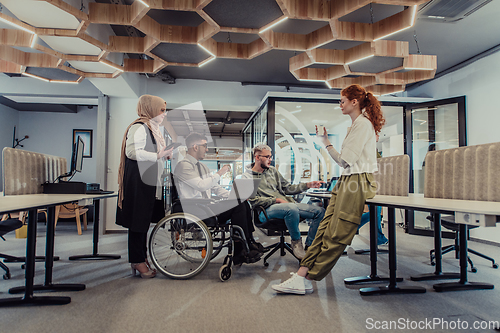 Image of Young group of business people brainstorming together in a startup space, discussing business projects, investments, and solving challenges.