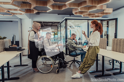 Image of Young group of business people brainstorming together in a startup space, discussing business projects, investments, and solving challenges.