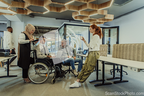 Image of Young group of business people brainstorming together in a startup space, discussing business projects, investments, and solving challenges.