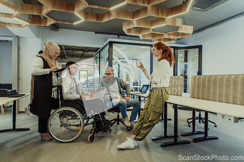 Image of Young group of business people brainstorming together in a startup space, discussing business projects, investments, and solving challenges.