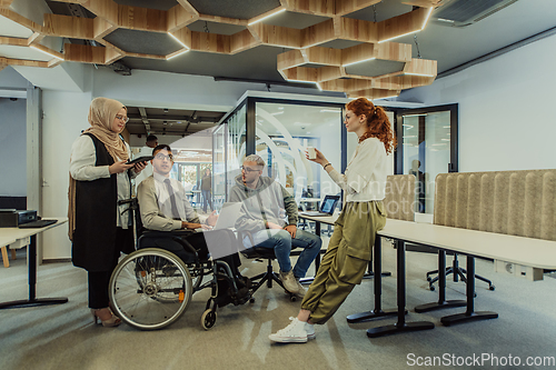 Image of Young group of business people brainstorming together in a startup space, discussing business projects, investments, and solving challenges.