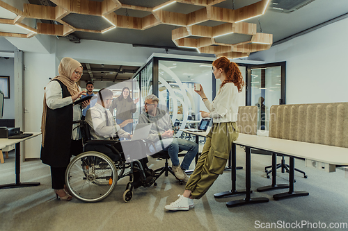 Image of Young group of business people brainstorming together in a startup space, discussing business projects, investments, and solving challenges.