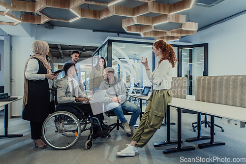 Image of Young group of business people brainstorming together in a startup space, discussing business projects, investments, and solving challenges.