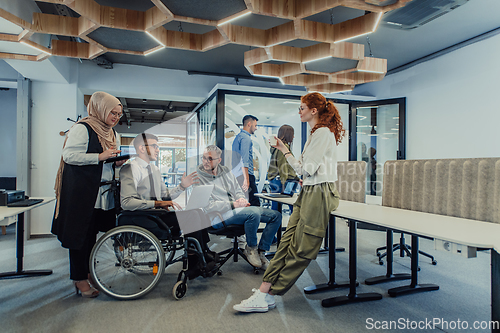 Image of Young group of business people brainstorming together in a startup space, discussing business projects, investments, and solving challenges.