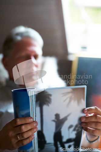 Image of Relax, magazine or mature man reading newspaper articles in home for information or story updates. Blur, book or senior person studying abstract art for knowledge in a publication in living room