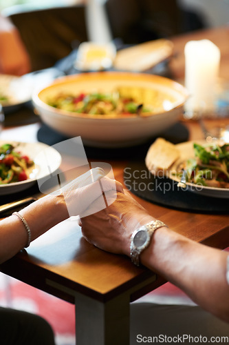 Image of Holding hands, home or couple praying for food or support at a dinner table together to celebrate. Christian religion, God or closeup of spiritual people eating lunch with faith, hope or gratitude