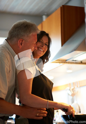 Image of Mature couple, embrace and cooking together with food, love and marriage at stove in home for lunch. Happiness, old man and woman in kitchen with hug, smile and meal prep for dinner in apartment.