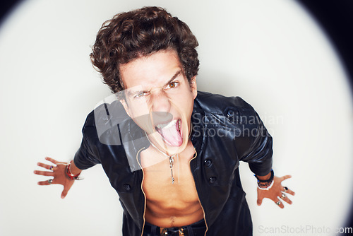 Image of Man, tongue and leather jacket in studio portrait with spotlight, fashion and clothes by white background. Person, top view and rockstar for crazy face, shouting or jewelry for punk aesthetic