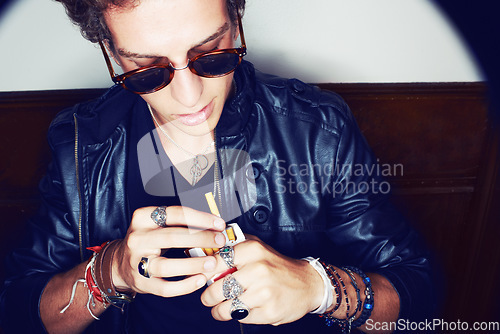 Image of Man with cigarette in hand, grunge fashion and rockstar attitude on white background in spotlight. Cool punk style, rebel and smoking, confident and handsome male model in studio with sunglasses.