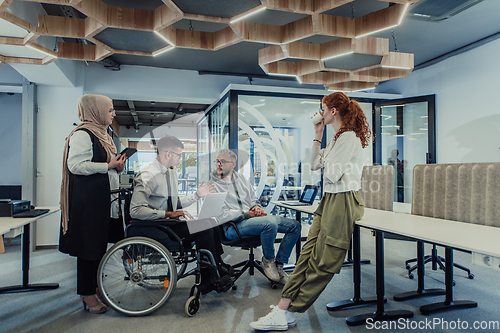 Image of Young group of business people brainstorming together in a startup space, discussing business projects, investments, and solving challenges.