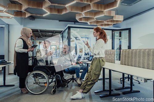 Image of Young group of business people brainstorming together in a startup space, discussing business projects, investments, and solving challenges.